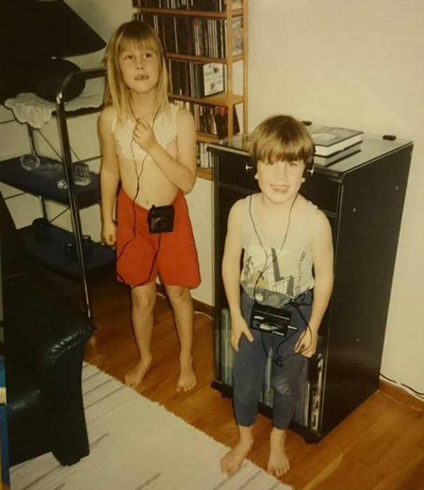 ”Jag och min bror Alexander står framför pappas vinylspelare, som vi ofta samlades runt om. Många helger under min uppväxt tillbringades med att på måfå testa pappas hundratals skivor i hopp om att upptäcka något häftigt.” Foto: Privat